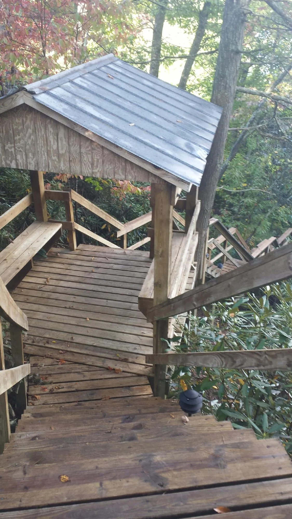Metal roofed shelter over wooden steps on a wooded walkway — Skylight Repair & Installation work by our crew in New Lenox