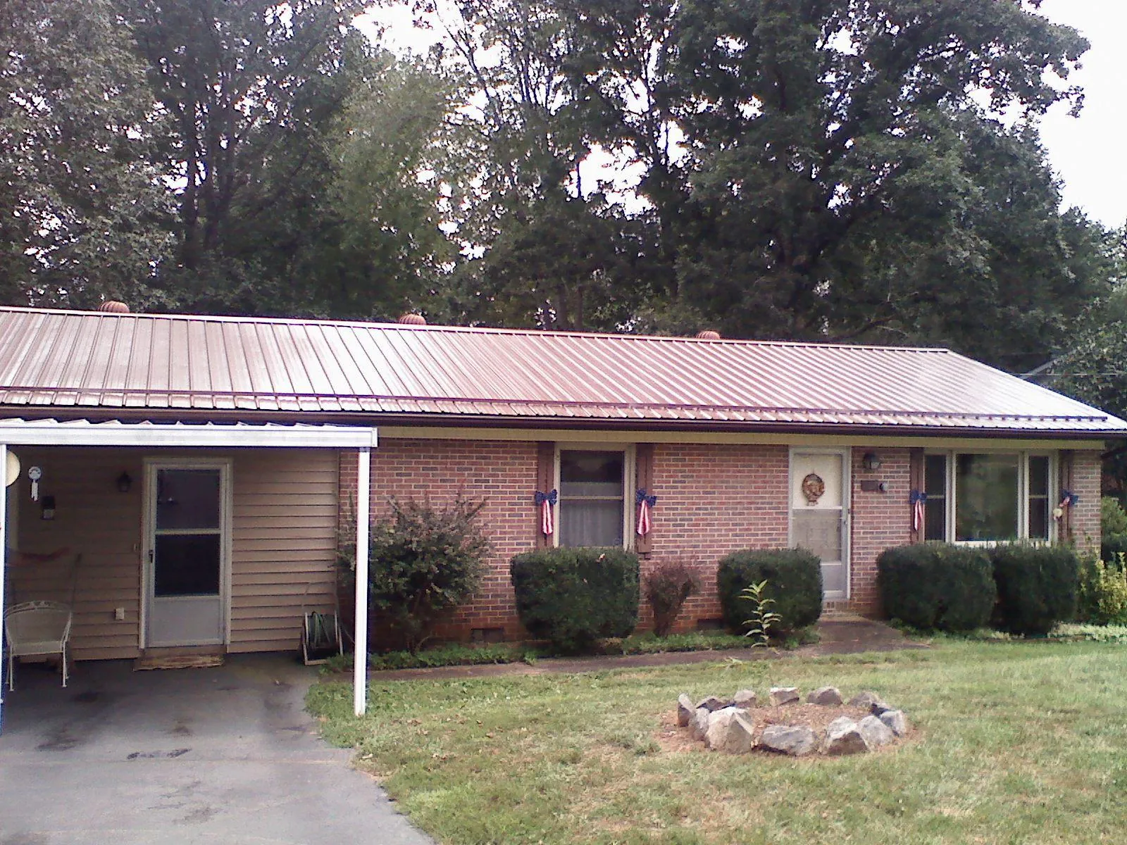 Bronze metal roof and carport on a brick ranch home — Roof Repair work by our crew in New Lenox