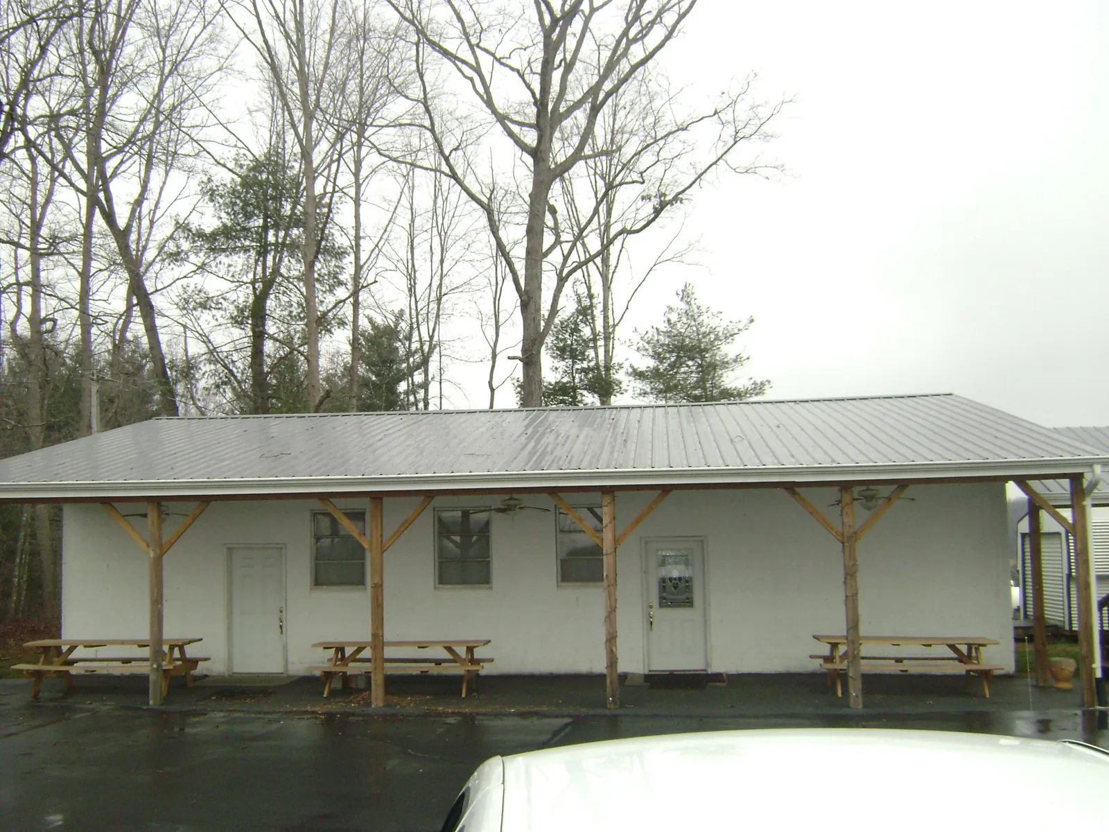 Gray metal roof over a block building with a timber post porch in New Lenox
